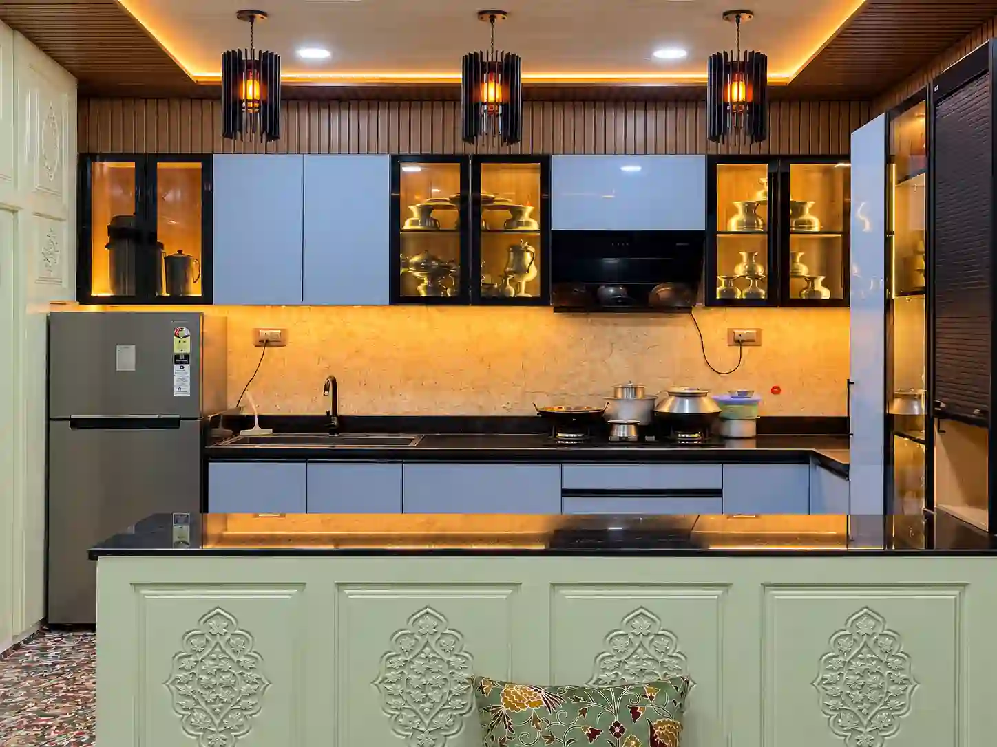 Blue modular kitchen with illuminated display cabinets, black worktop, and island counter